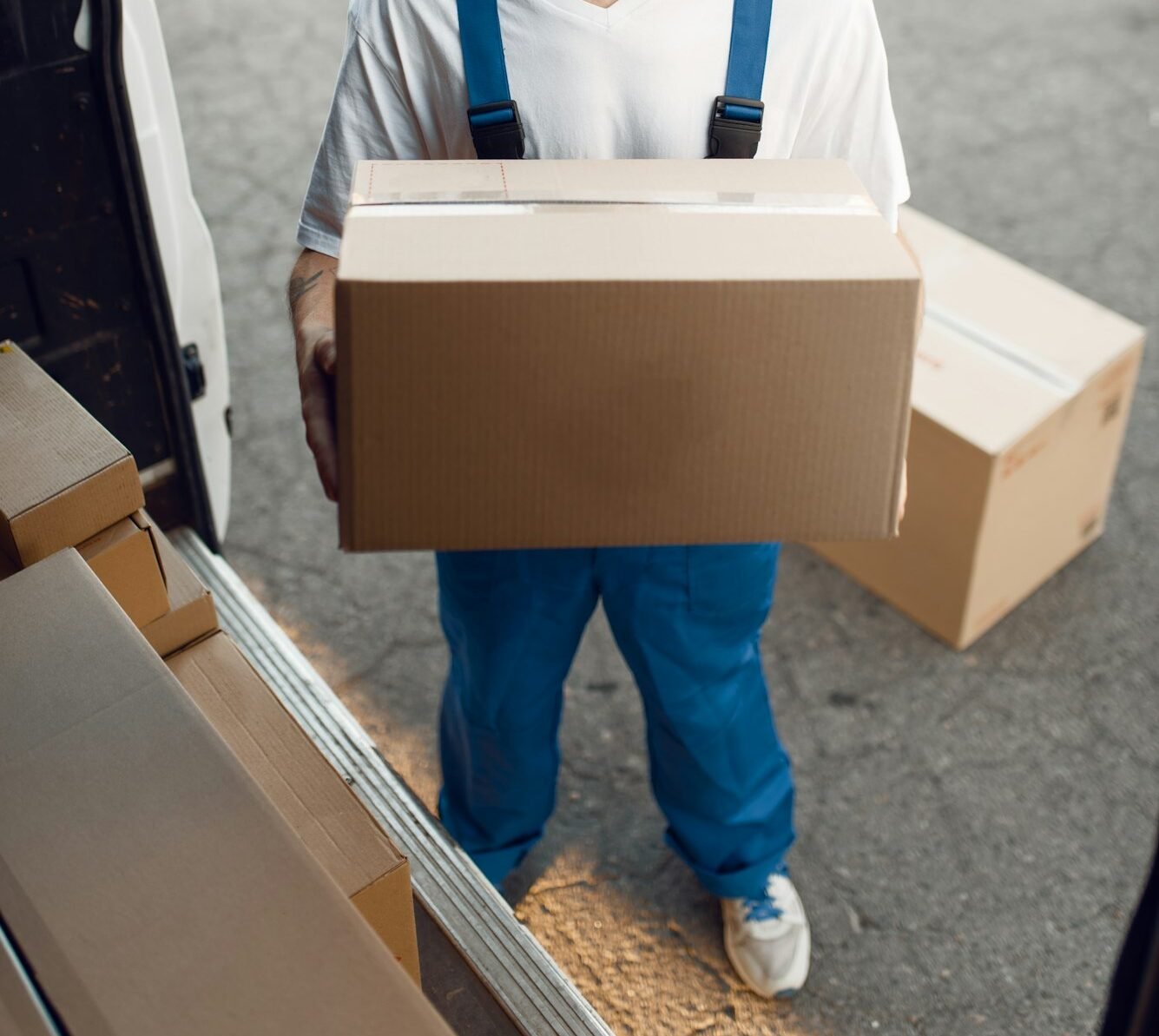 Deliveryman unloads the car with parcels, delivery